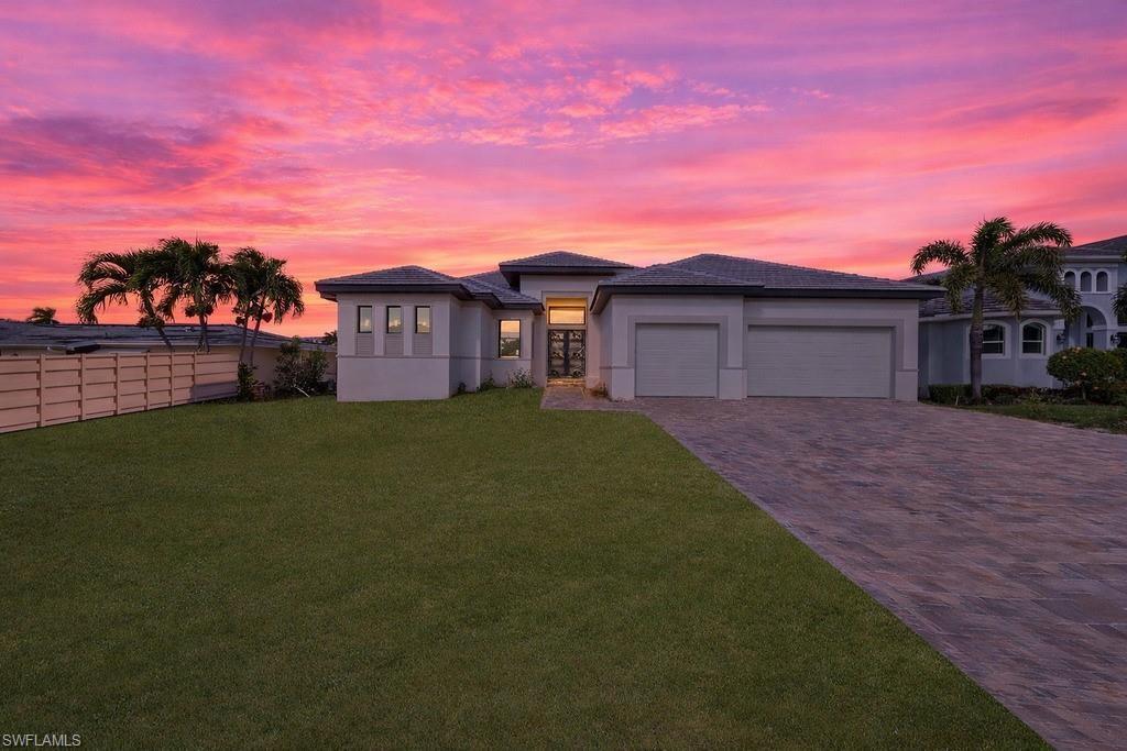 Prairie-style home with decorative driveway, an attached garage, and stucco siding
