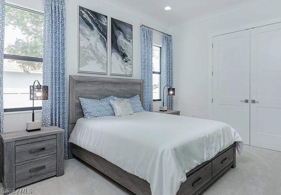 Bedroom with crown molding, light colored carpet, and recessed lighting