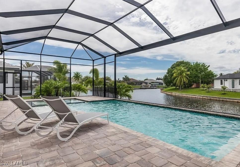 Outdoor pool featuring a water view, a lanai, a sunroom, and a patio area
