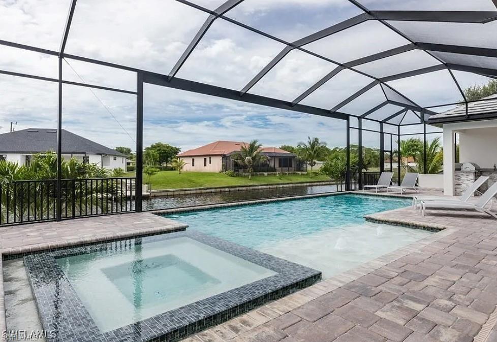 View of swimming pool with a sunroom, a patio, a pool with connected hot tub, and a lanai