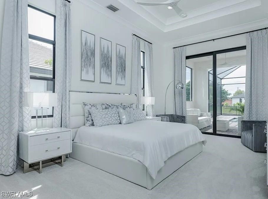 Carpeted bedroom with access to outside, a sunroom, crown molding, ceiling fan, and a raised ceiling