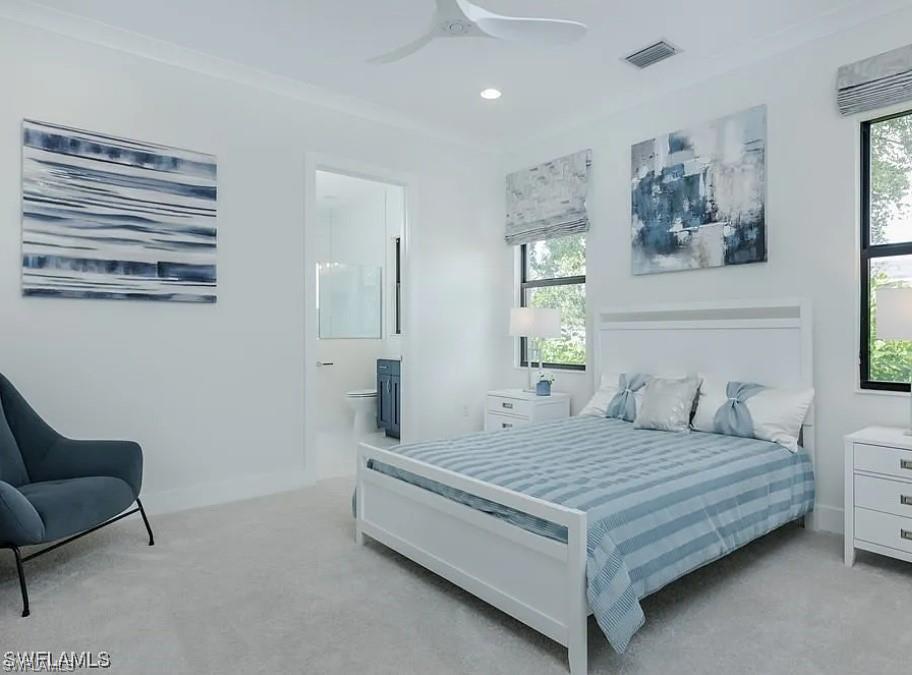 Bedroom with light carpet, ornamental molding, ceiling fan, recessed lighting, and ensuite bathroom