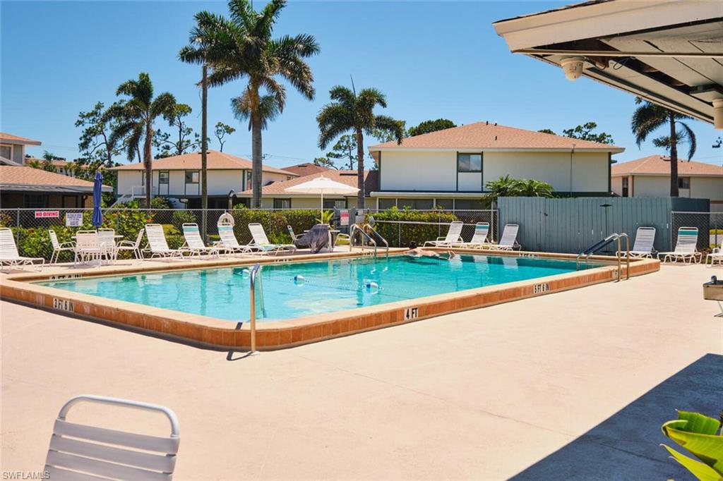 Community pool with a patio area and a residential view