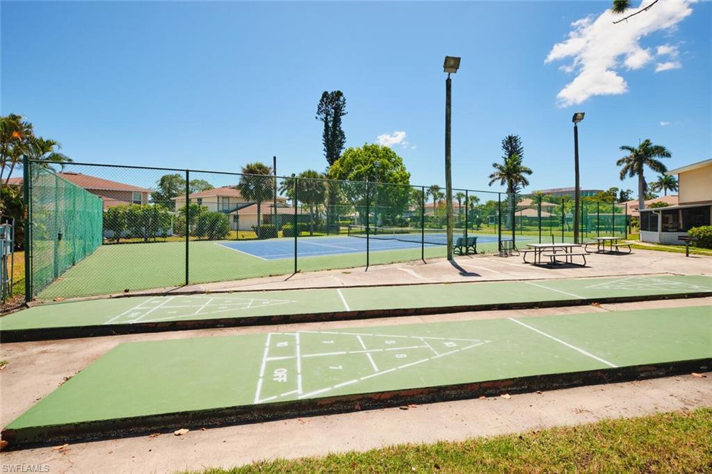 View of community featuring a tennis court and shuffleboard