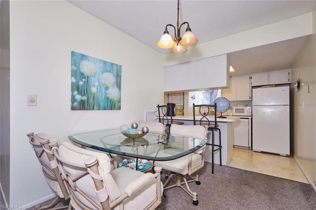 Dining area featuring a chandelier and light carpet
