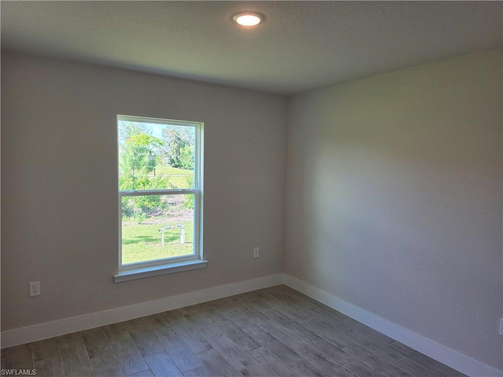 Neutral-toned wall finish with white trim, recessed lighting, and wood-look tile flooring