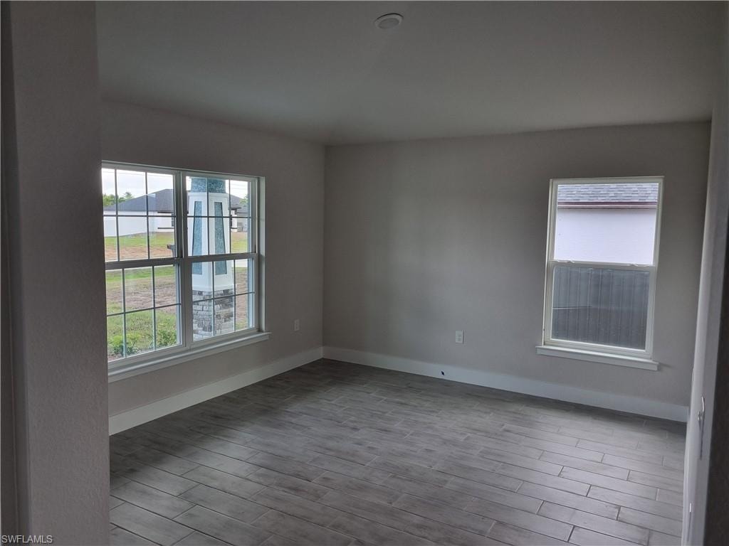 Unfurnished room with light wood-style flooring and baseboards