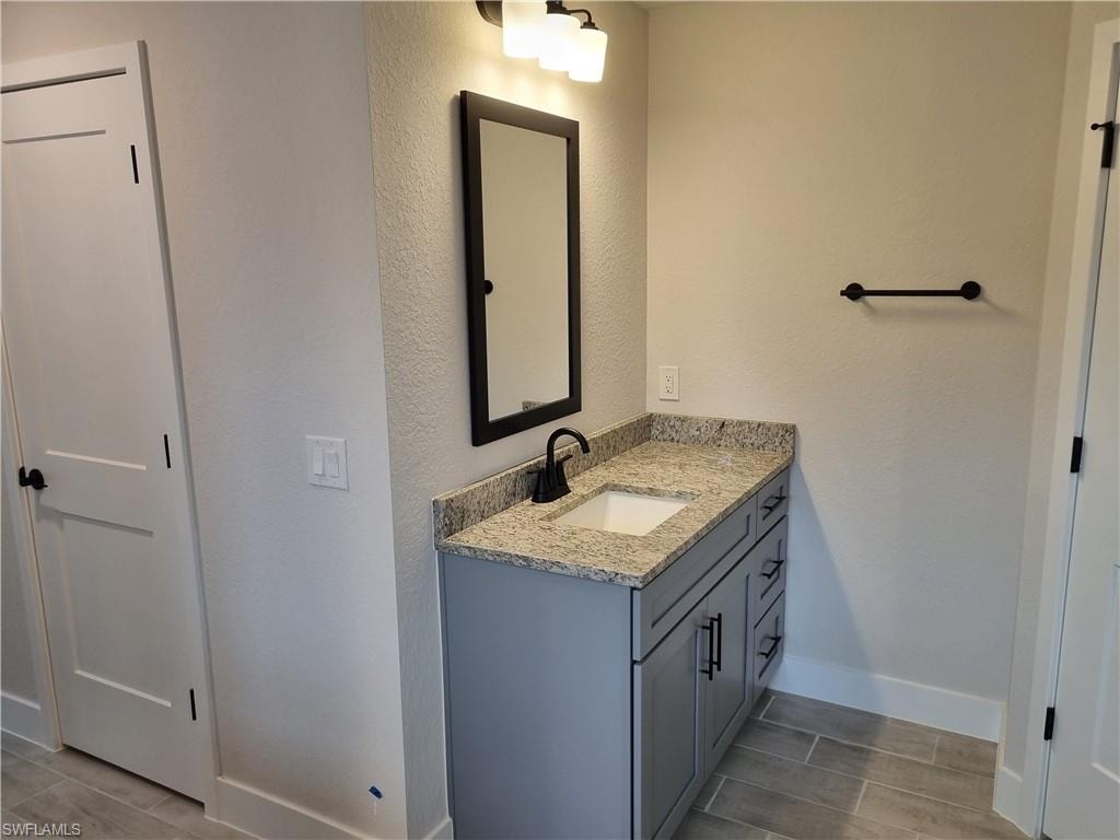 Bathroom featuring vanity, wood tiled floors, and a textured wall