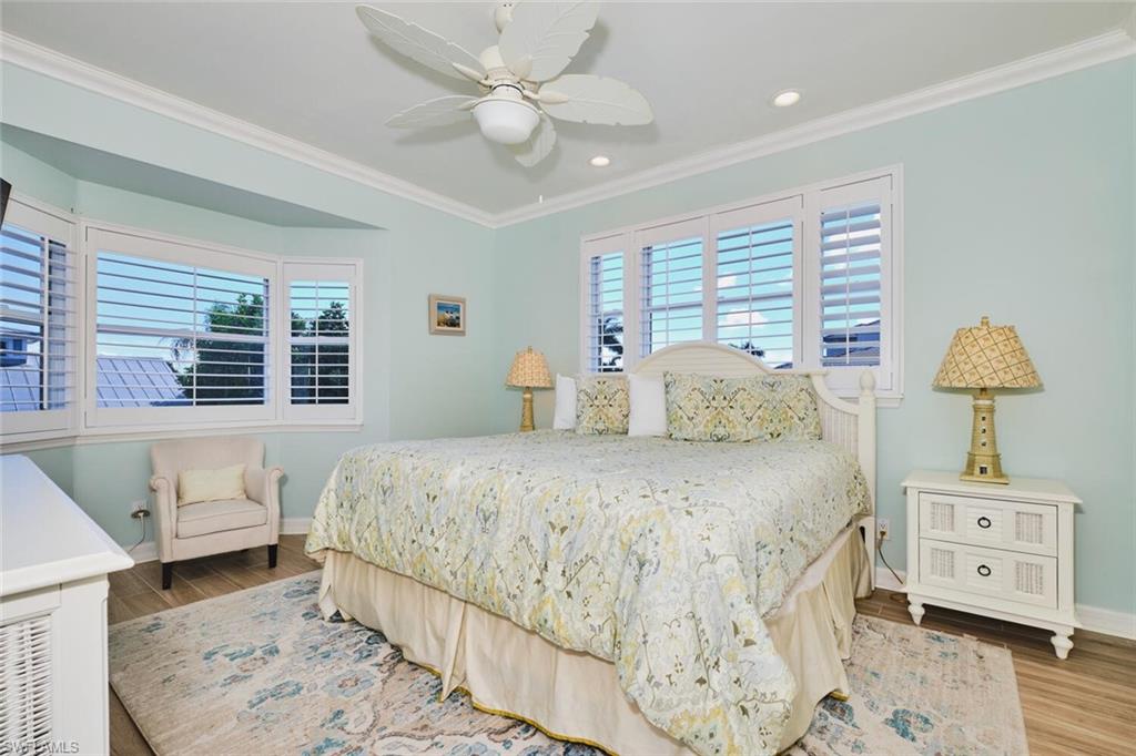 Main living area - Bedroom featuring multiple windows, crown molding, wood finished floors, a ceiling fan, and recessed lighting