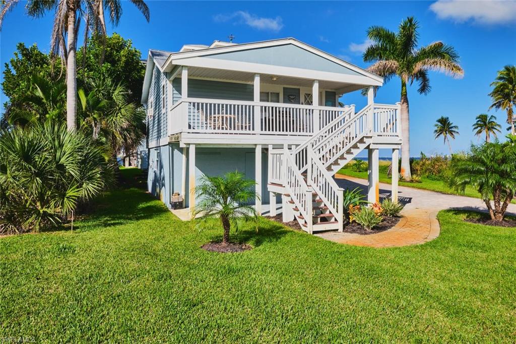 Back of property featuring a yard and stairs