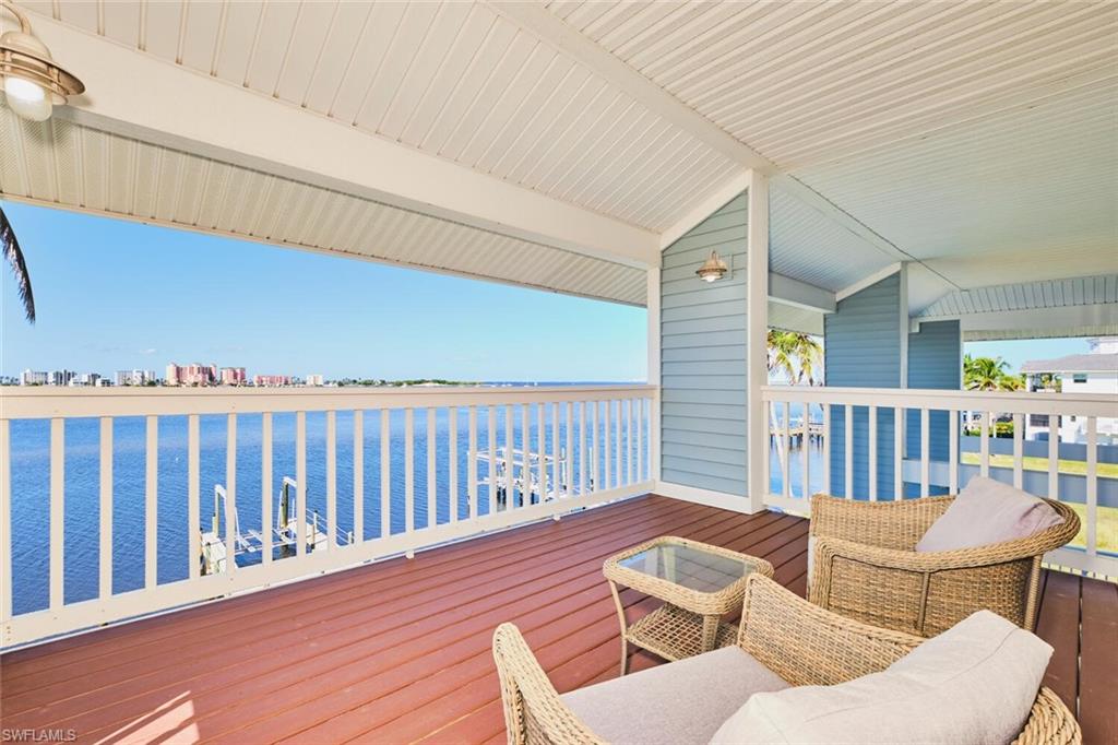 Primary bedroom - Wooden deck featuring a water view