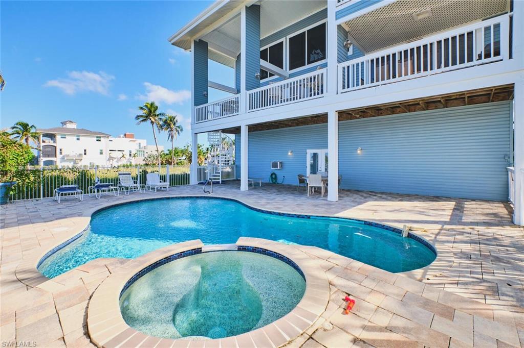 Pool off of first floor apartment - View of pool with a patio area, a pool with connected hot tub, a balcony, and stairway