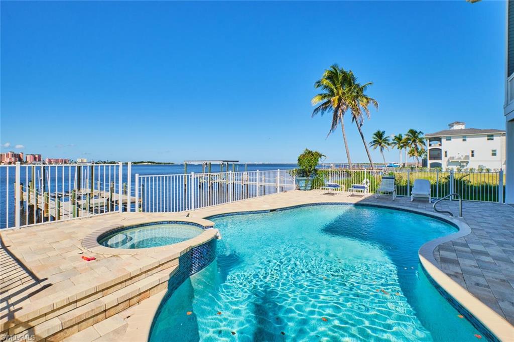 First floor View of pool featuring a pool with connected hot tub, a water view, and a patio area