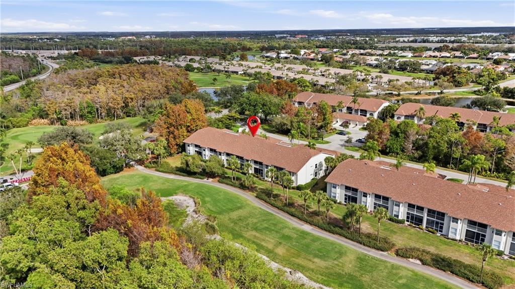Aerial view of property and surrounding area with a golf course and a large body of water