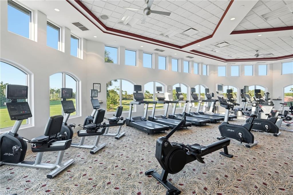 Workout area with ceiling fan and a high ceiling
