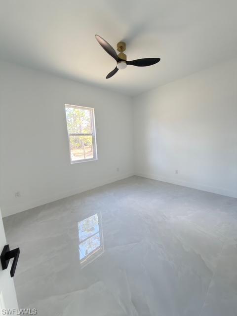 Empty room featuring a ceiling fan and concrete floors