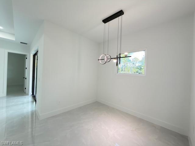 Unfurnished dining area featuring baseboards and finished concrete flooring