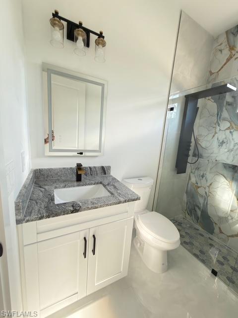 Full bath featuring vanity and a marble finish shower