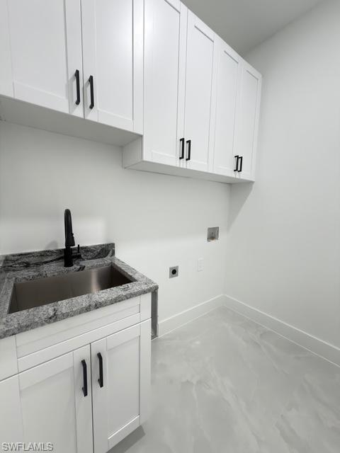 Laundry room with hookup for an electric dryer, finished concrete floors, cabinet space, and hookup for a washing machine