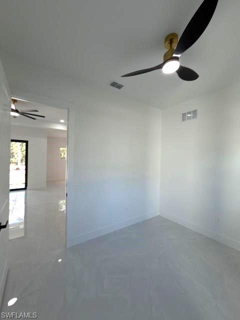 Unfurnished room with a ceiling fan and baseboards