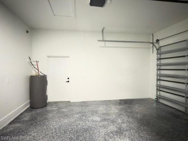 Garage featuring water heater and a garage door opener