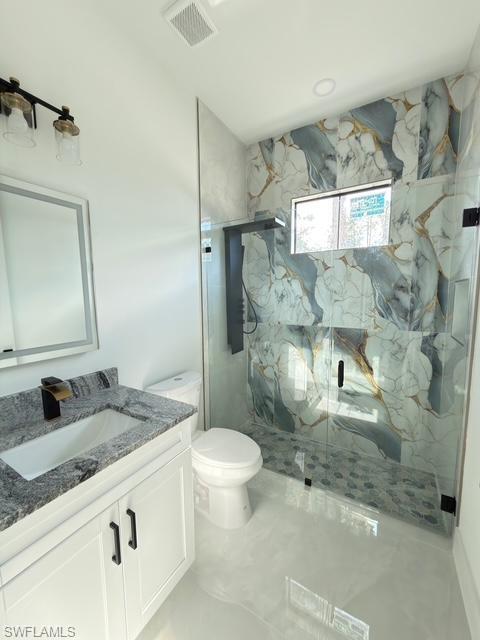 Full bath featuring vanity and a marble finish shower