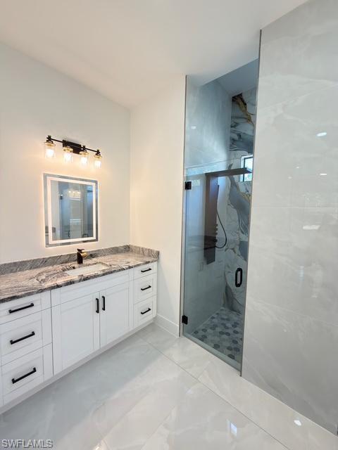 Bathroom featuring vanity and a shower stall