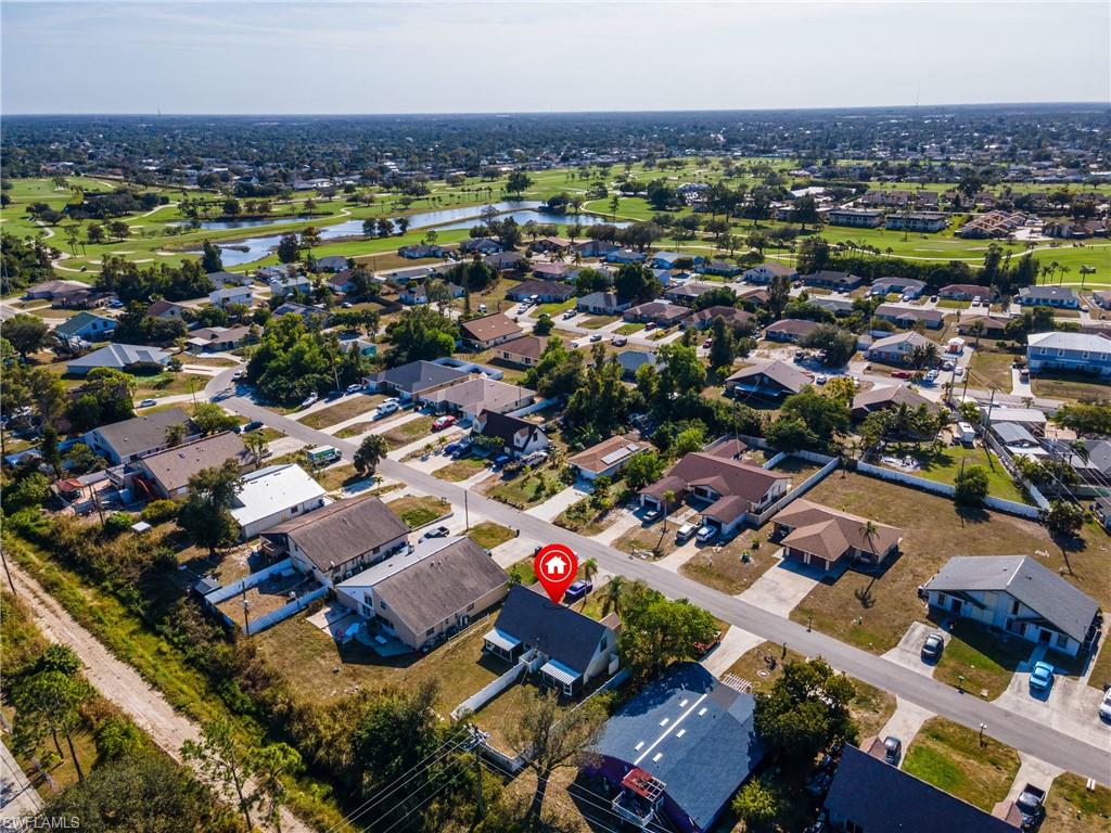 Aerial perspective of suburban area featuring a nearby body of water