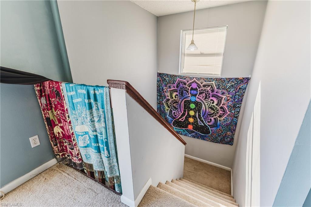Stairway featuring carpet and a textured ceiling