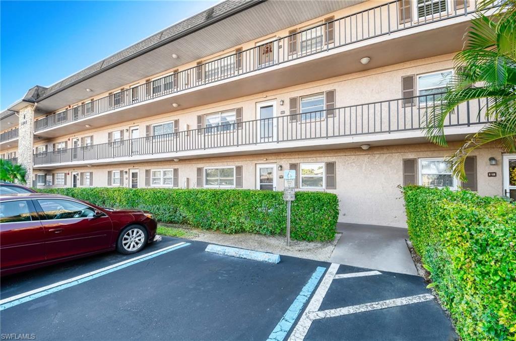 View of apartment building / complex featuring uncovered guest parking
