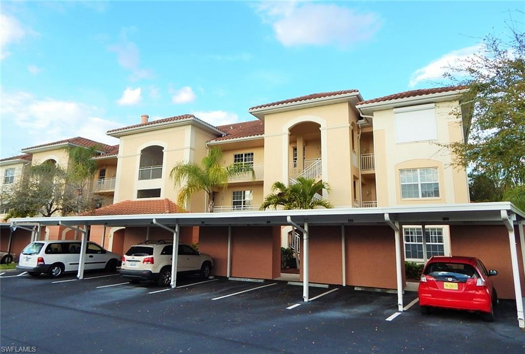 View of apartment building / complex with covered parking