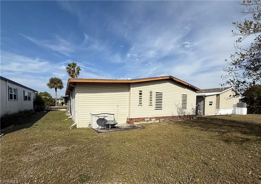 View of home's exterior featuring a lawn and a patio