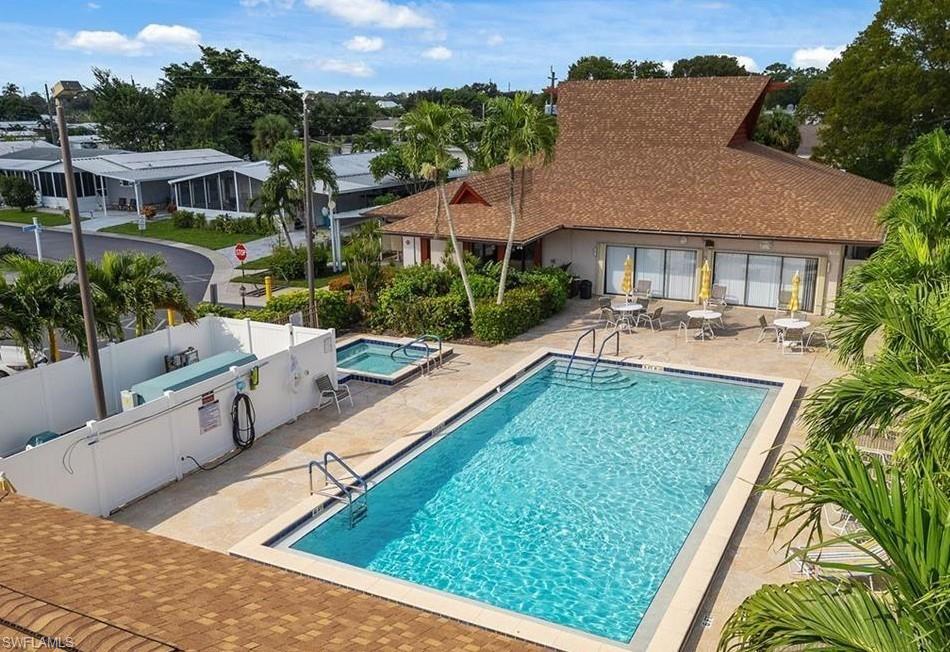 Community pool with a patio and a hot tub