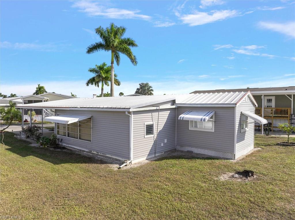 Rear view of property featuring a yard and a metal roof