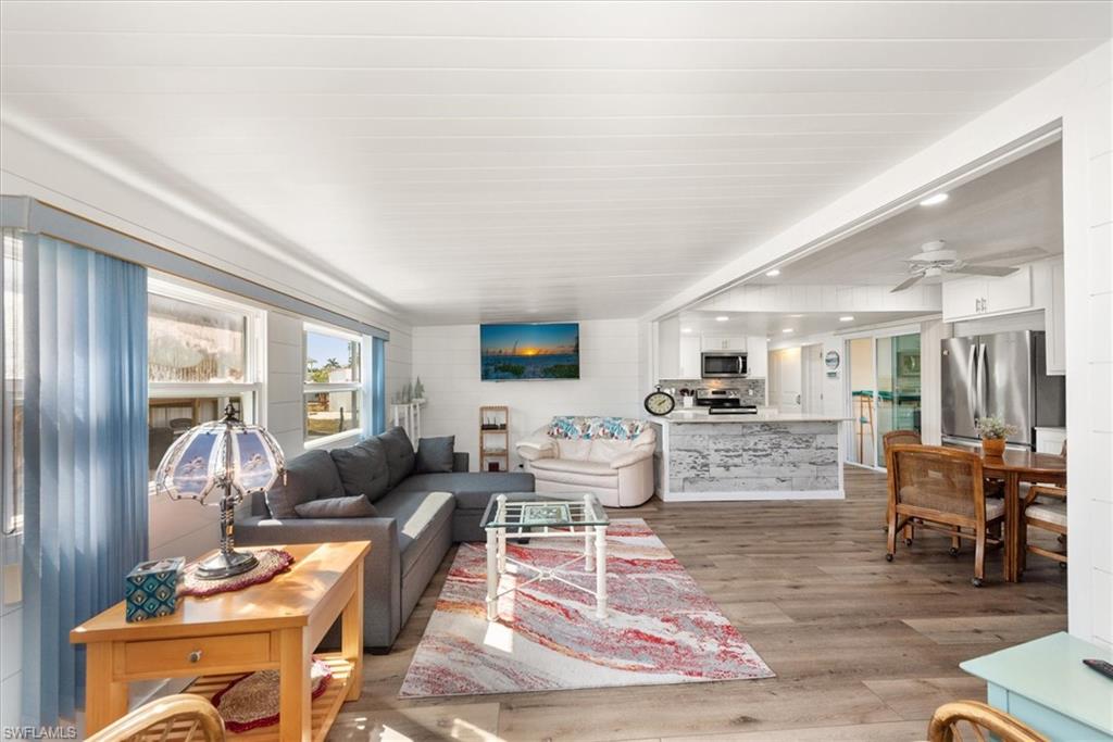 Living area with light wood-style flooring, recessed lighting, and ceiling fan