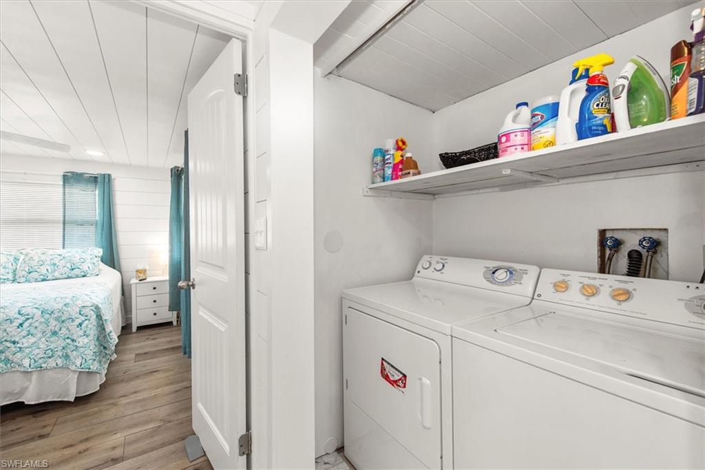 Laundry area with light wood-style flooring and washer and dryer