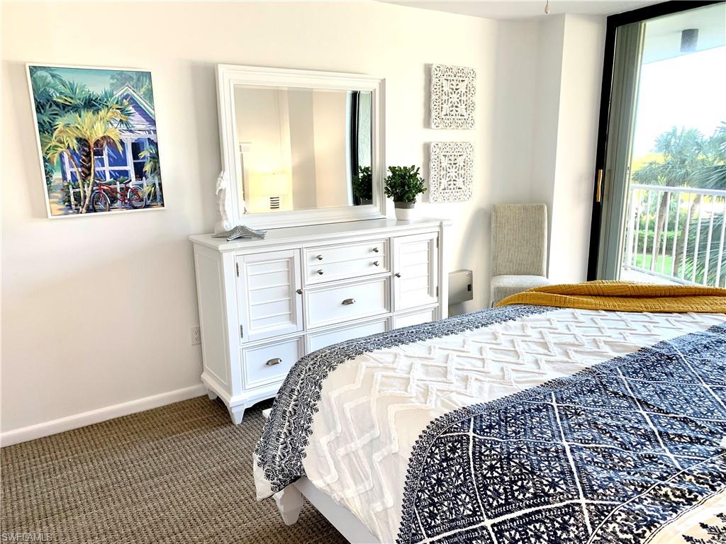 Bedroom featuring dark colored carpet and baseboards