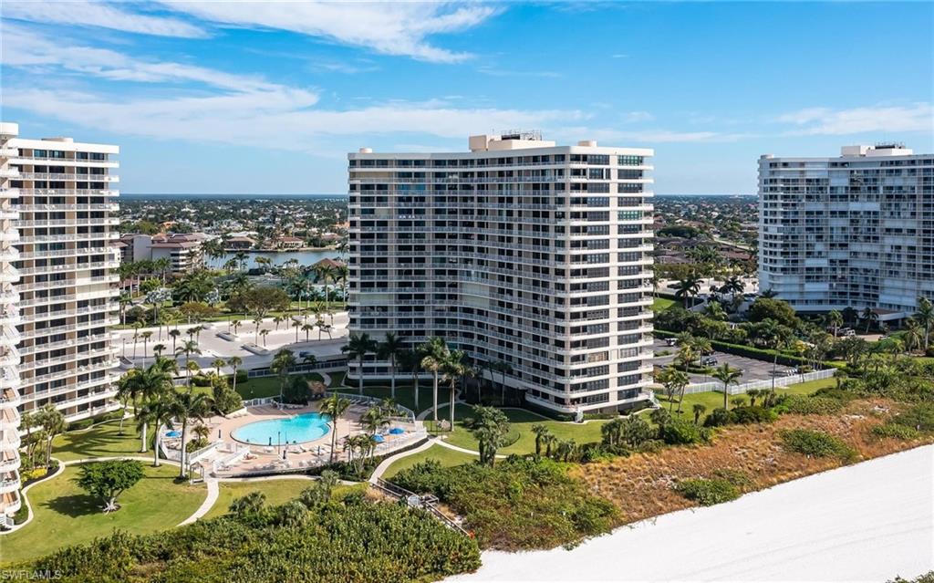 View of apartment building / complex with a community pool, a view of city, and a water view