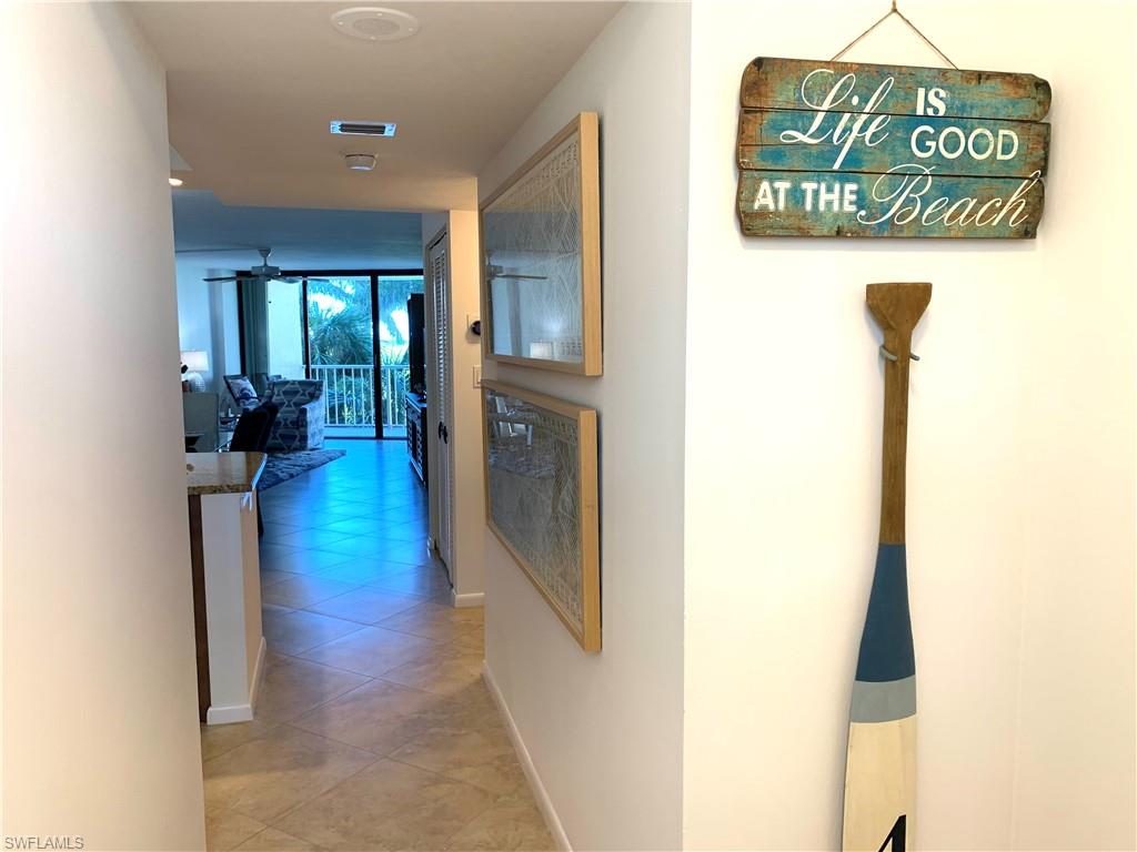 Hall with baseboards and light tile patterned floors