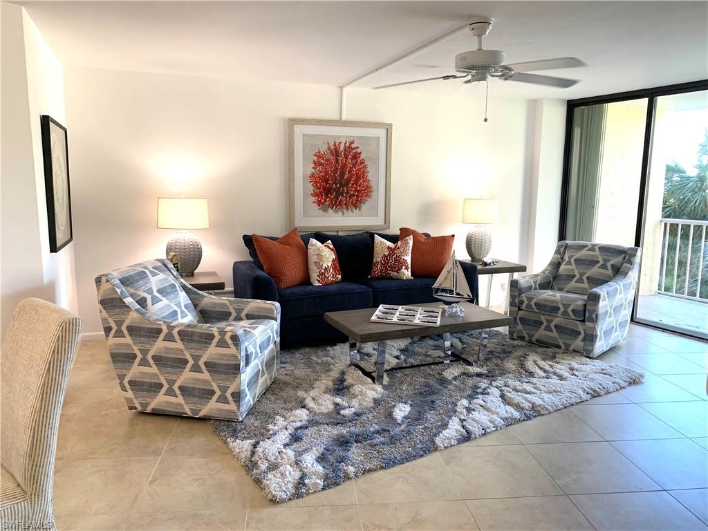 Living area with floor to ceiling windows, a ceiling fan, and light tile patterned floors