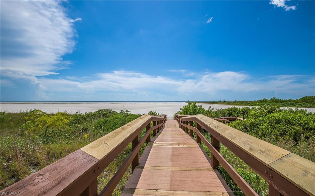 Surrounding community featuring view of water and beach