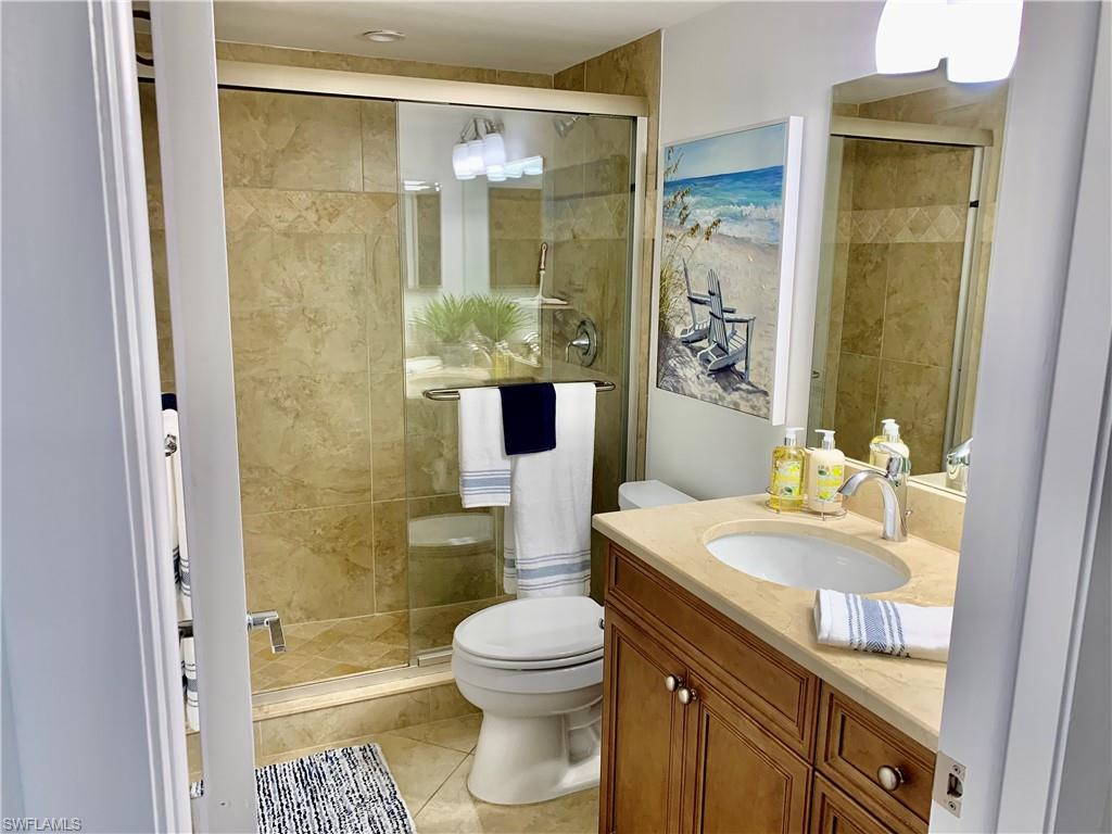 Full bath featuring vanity, a stall shower, and light tile patterned flooring