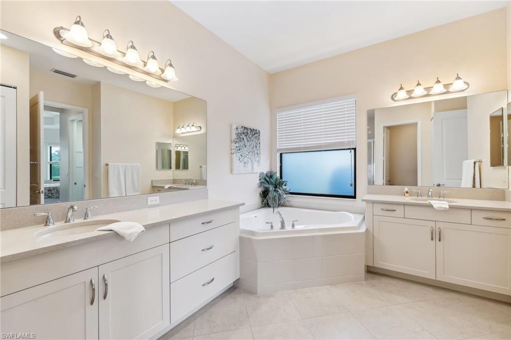Primary ensuite bathroom with dual countertops, soaking tub