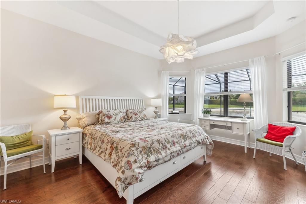 First floor primary suite with sitting area and view of pool and lake