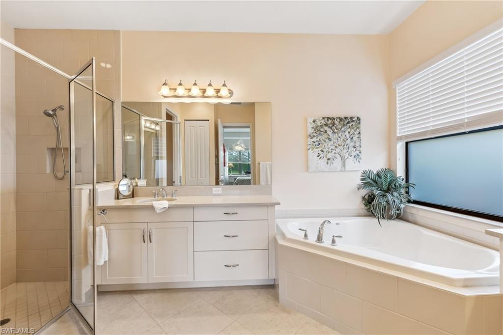 Primary bathroom with dual vanities, tub and shower