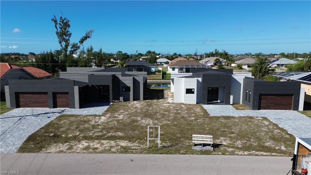 Contemporary home featuring a residential view, an attached garage, and decorative driveway