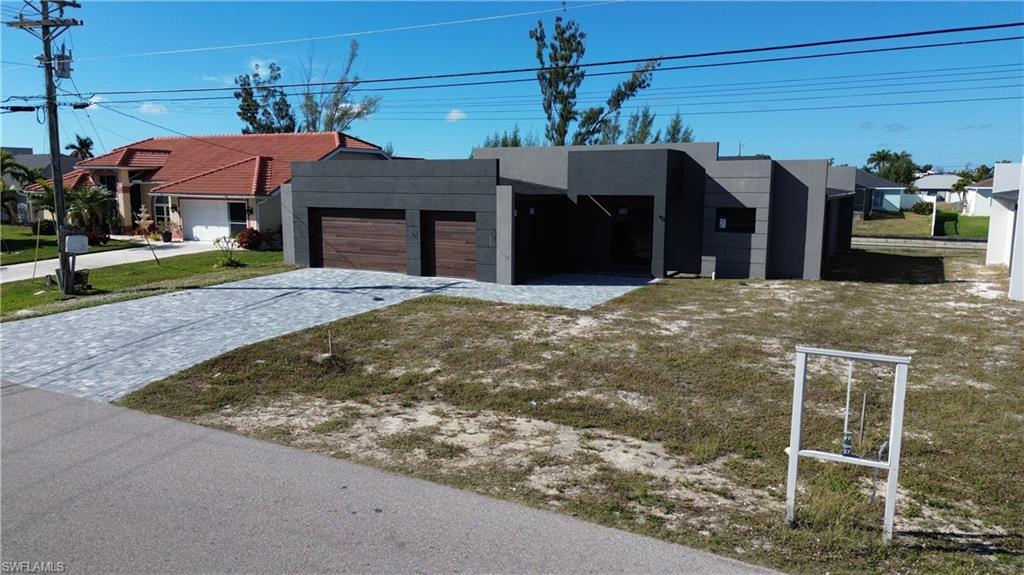 View of front of home featuring decorative driveway, stucco siding, and an attached garage