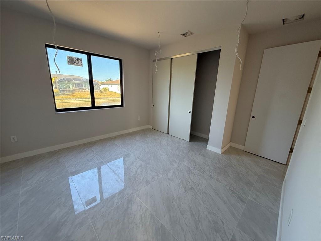 Unfurnished bedroom featuring a closet and baseboards