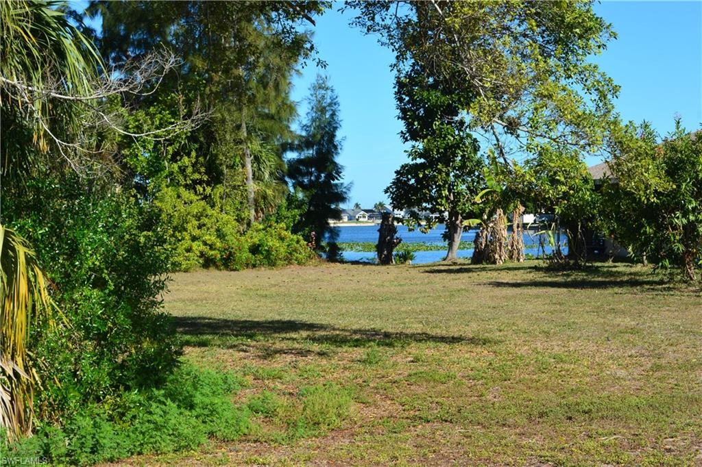 View of green lawn featuring a water view