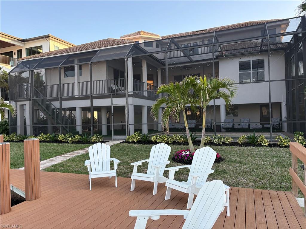 Deck with a lawn, glass enclosure, and stairway